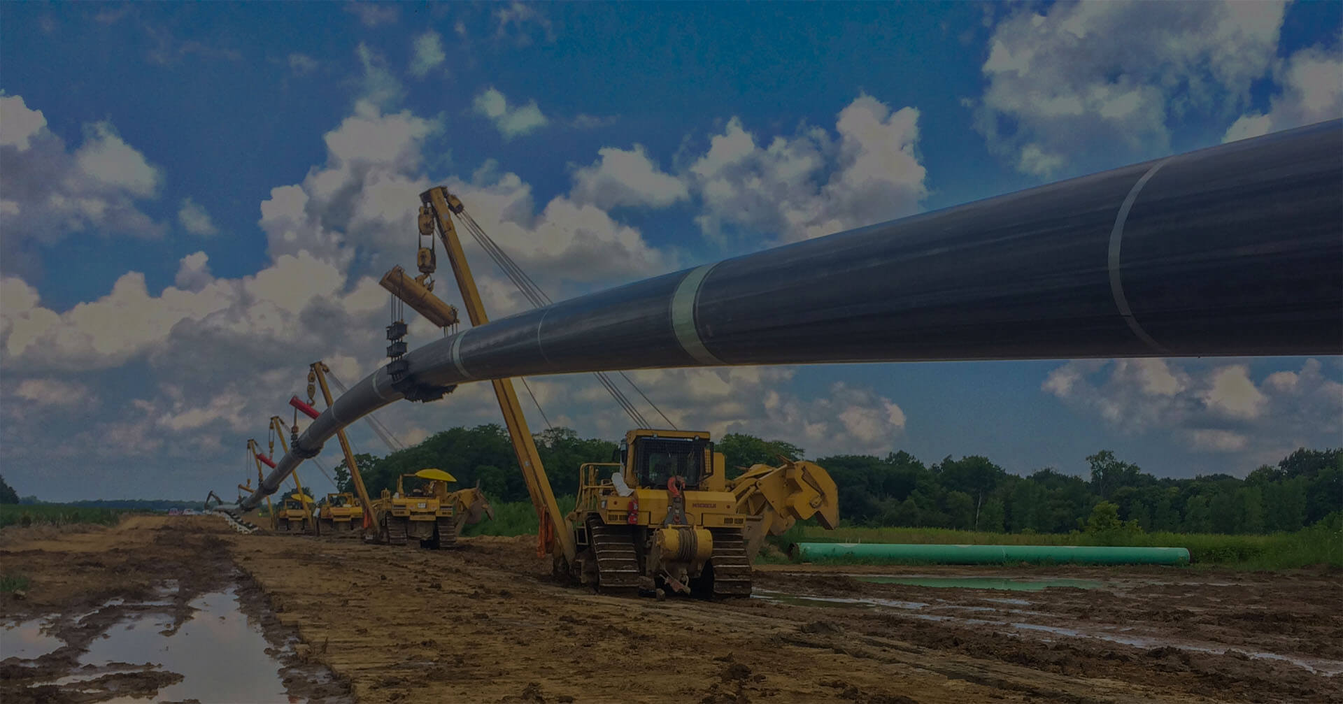 Pipelayers holding large pipeline