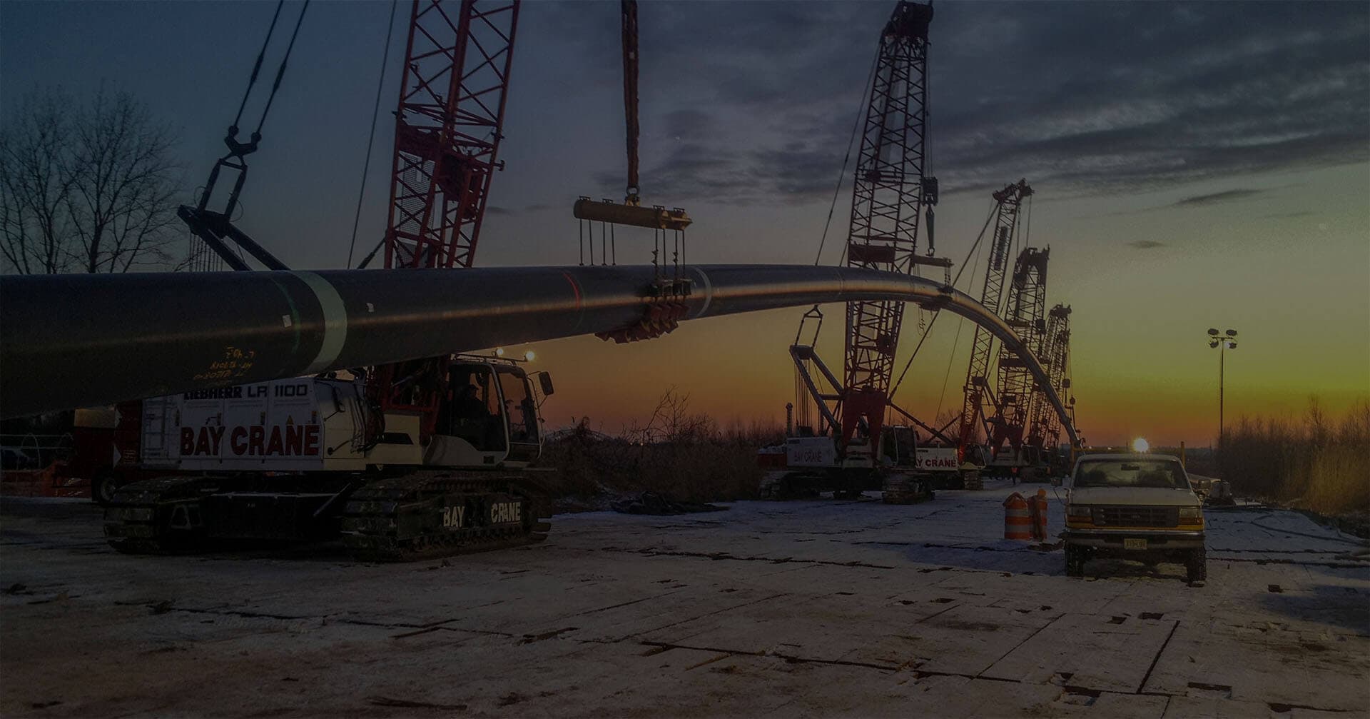Cranes holding up large pipe