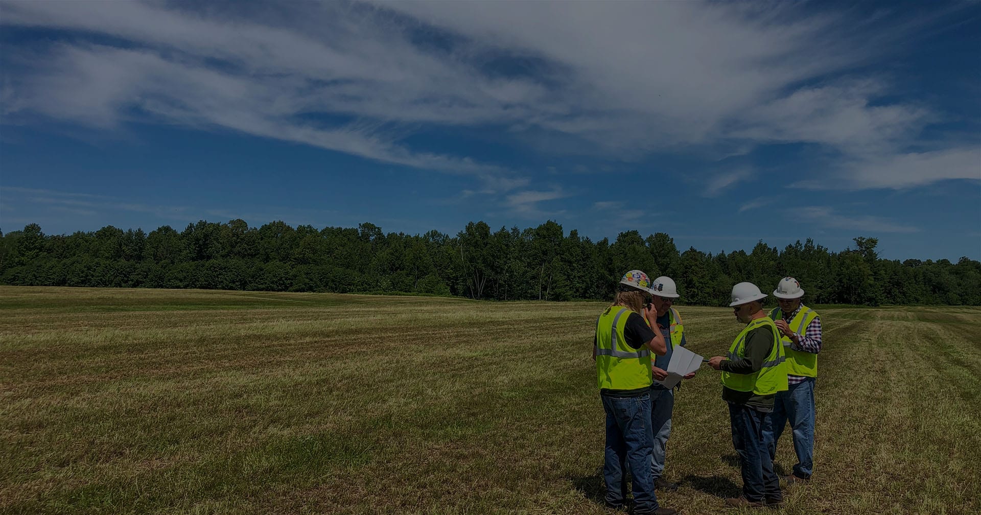 workers in group observing field landscape