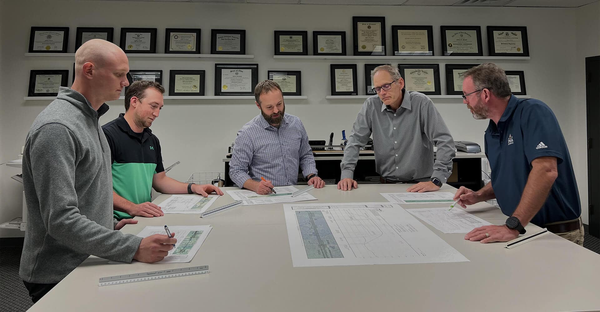 J.D. Hair team around a table of work plans