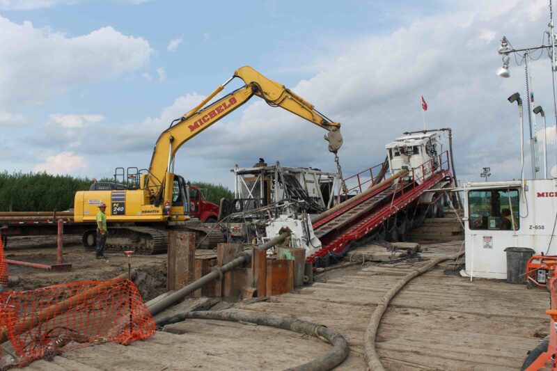 An HDD rig operates near a trackhoe.